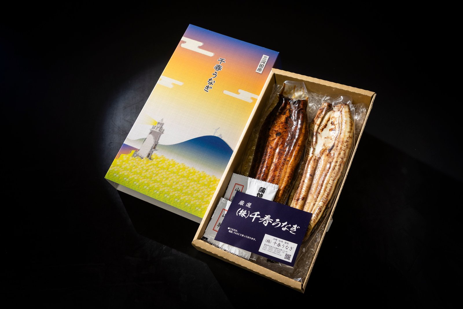 化粧箱に詰め合わせた千春うなぎの蒲焼と白焼、蒲焼のたれと山椒